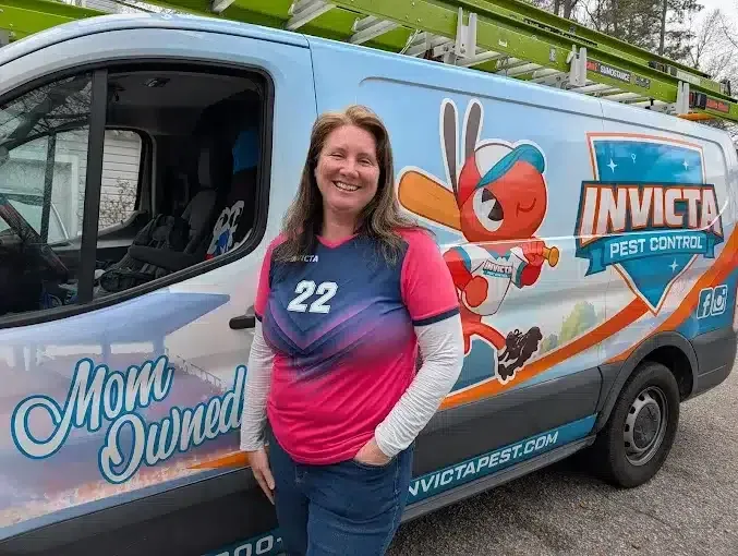 Owner Elizabeth Gilbert beside an Invicta Pest Control van