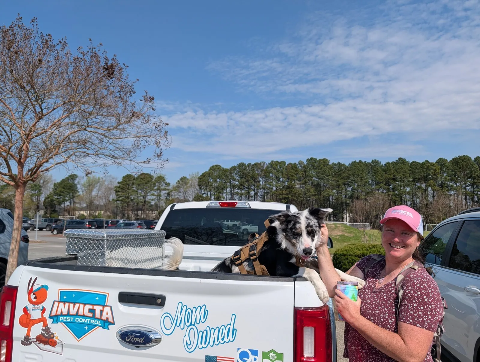 Invicta Pest Control truck with the Mom Owned logo and a dog riding in the back