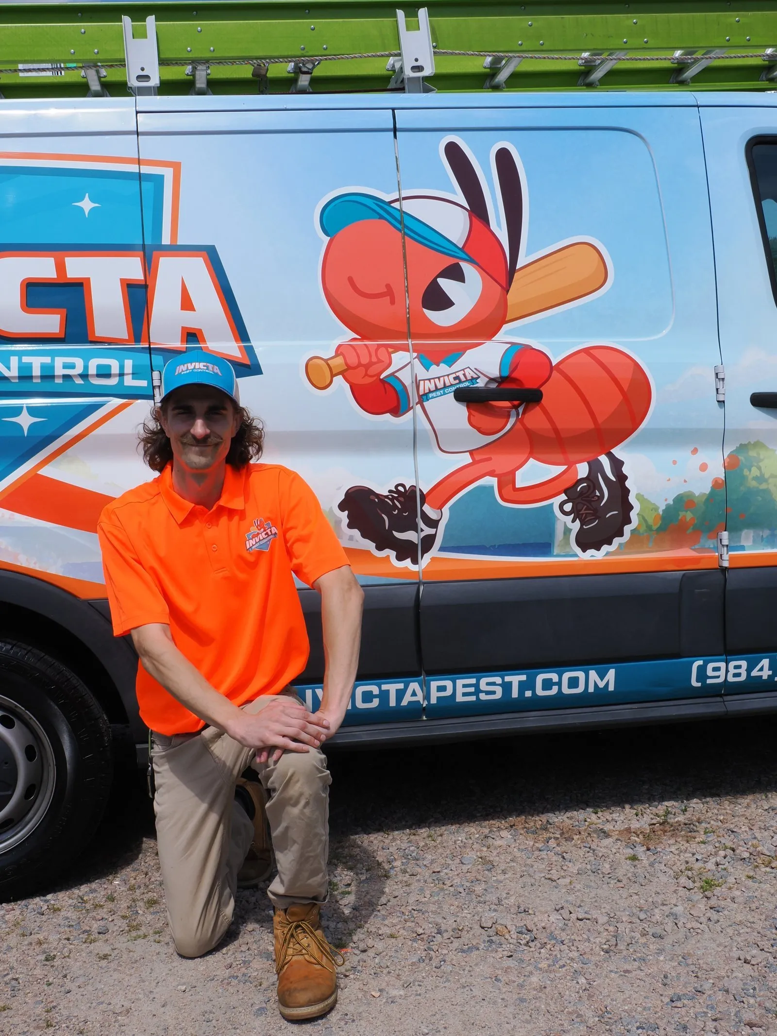 Invicta technician kneeling in front of an Invicta van