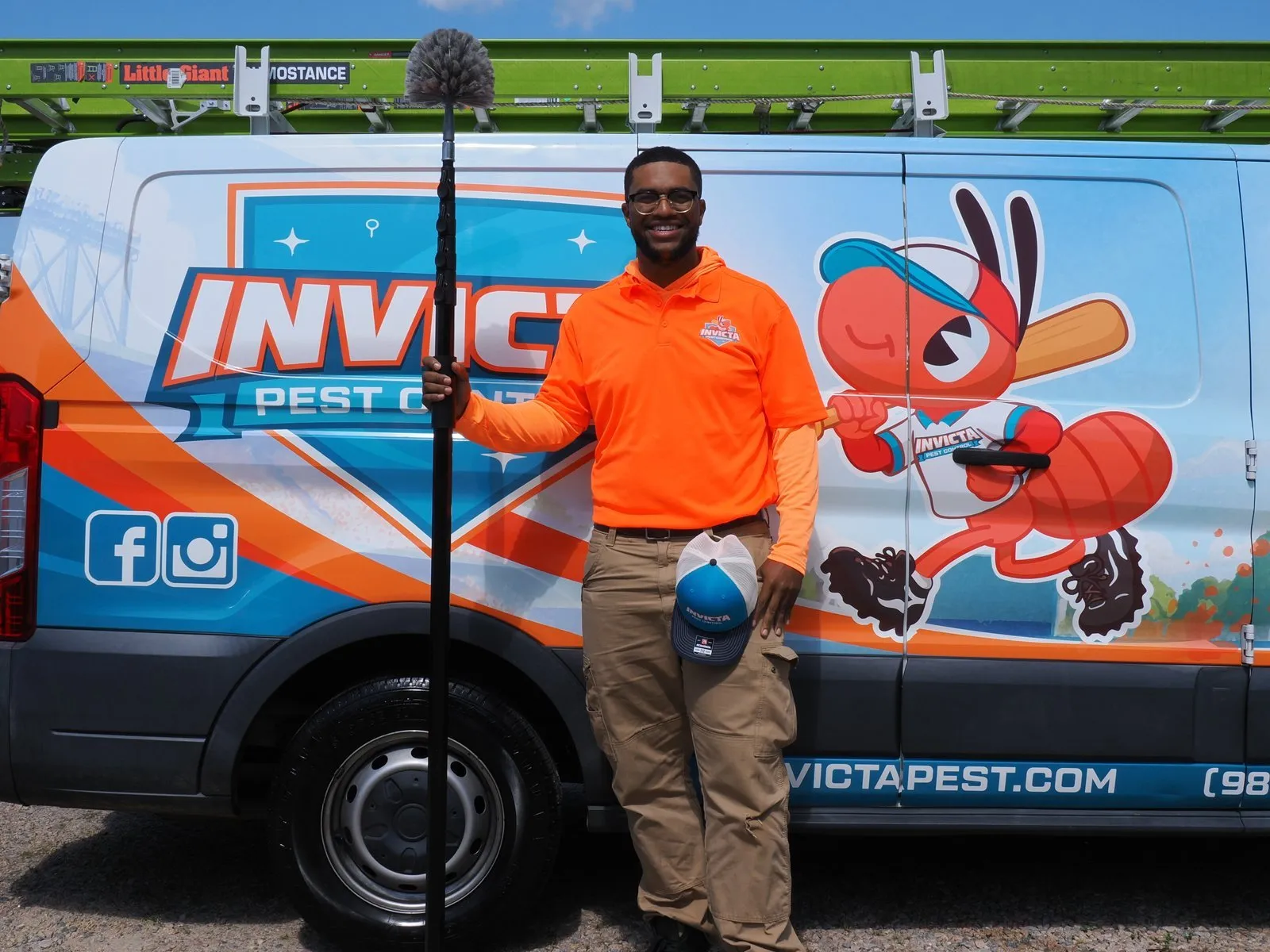 Invicta technician holding a web brush on an extension pole