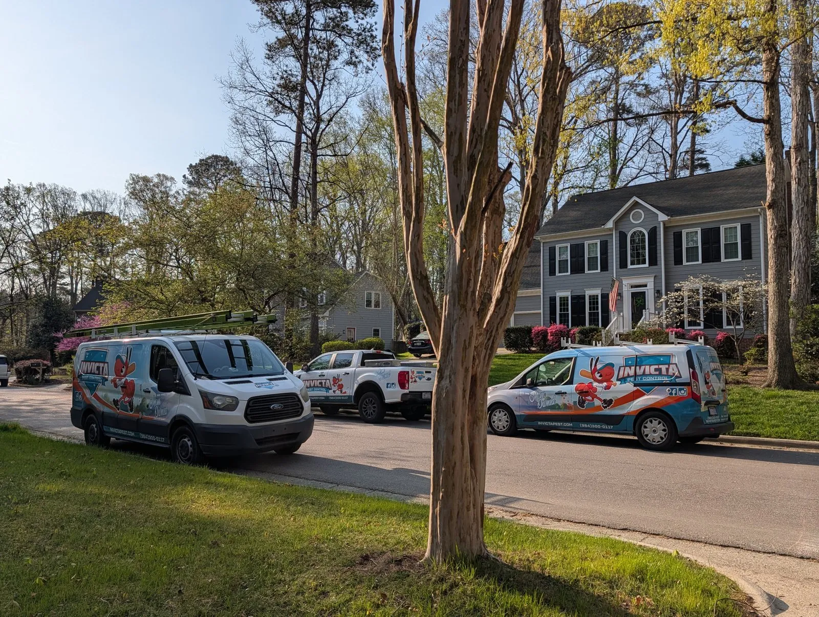 Invicta Pest Control vans and truck outside a customer’s home