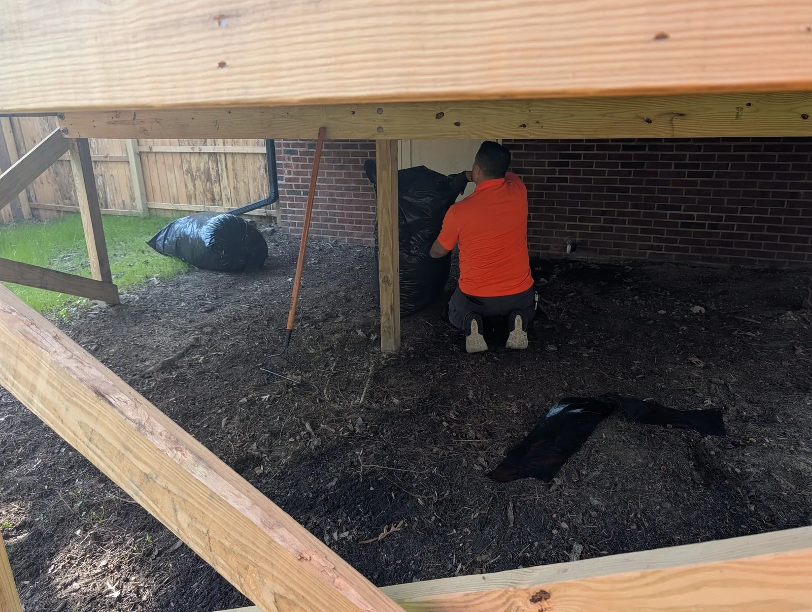 Invicta technician inspecting the soil under a deck